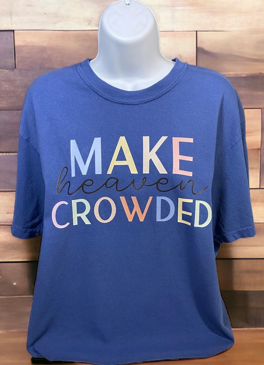 Picture of dark blue shirt on mannequin. Design on front reads "Make Heaven Crowded"